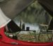Organized camping equipment beside an open rooftop tent
