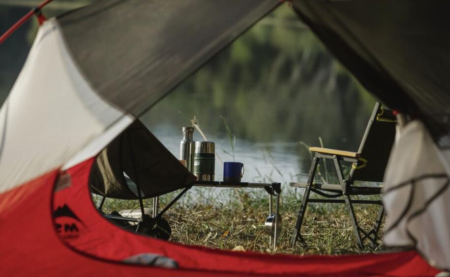 Organized camping equipment beside an open rooftop tent