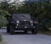 Black Jeep Wrangler driving slowly on a forest service road
